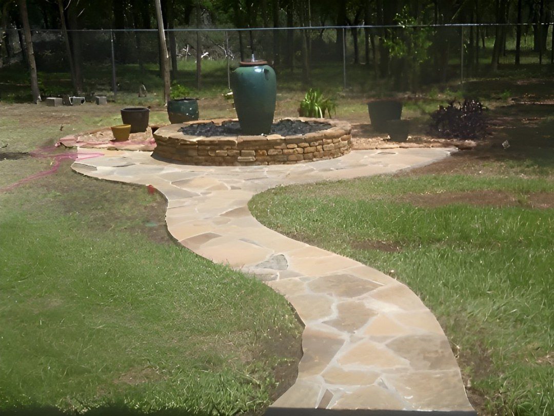 A walkway with a fountain and a fire pit.